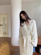 Cream long fleece robe tied at the waist in a sunny living room