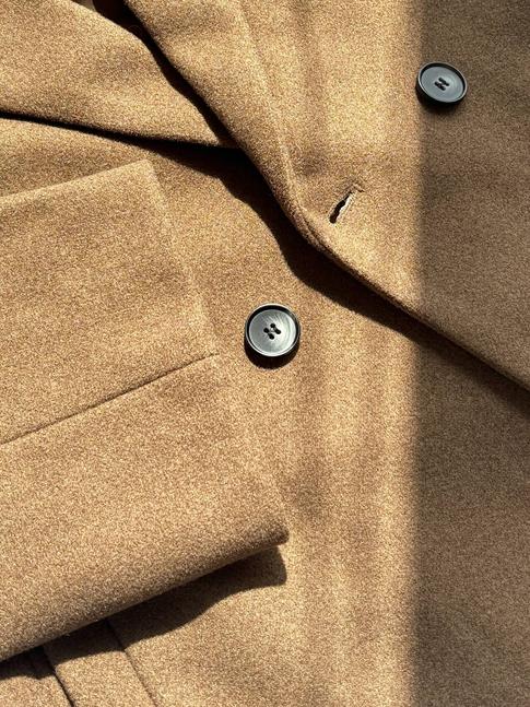 Detail of the buttons and lapel on the brown wool coat