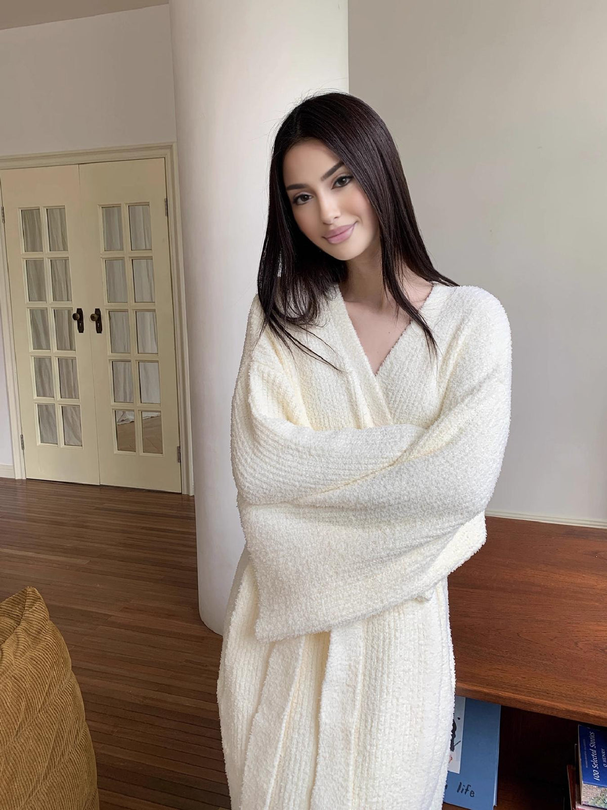 Cream plush robe worn cozy at home with oversized sleeves