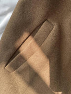 Close-up of the welt pocket on the brown wool coat