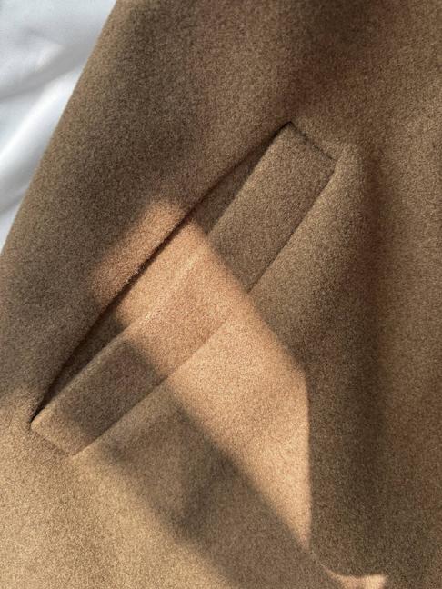 Close-up of the welt pocket on the brown wool coat