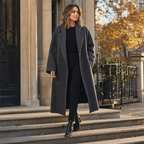 Woman in a charcoal grey long wool coat on city steps at golden hour